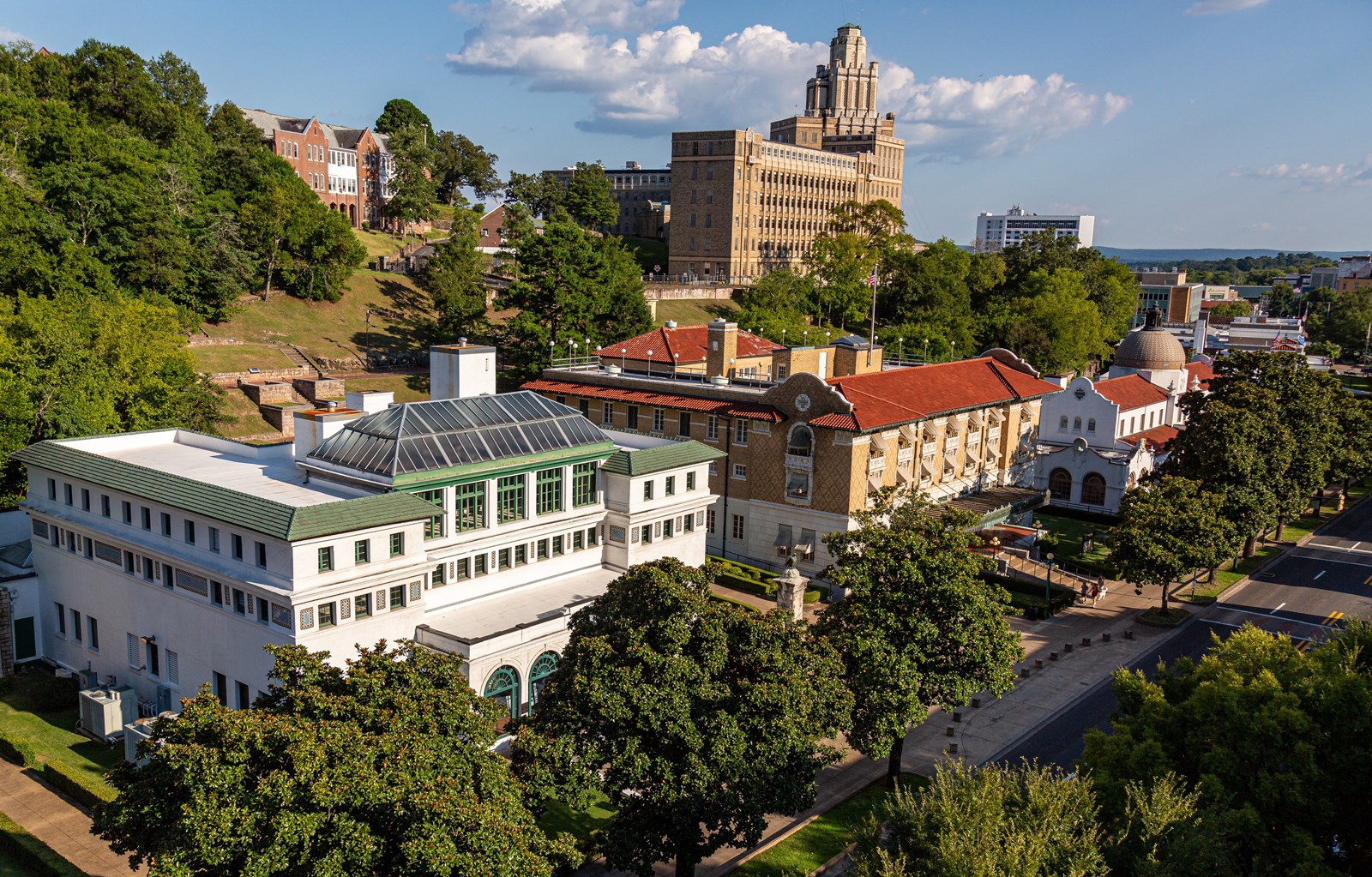 Historic Bathhouse Row surrounded by green mountains in Hot Springs